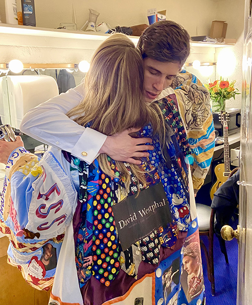 Webber's back is visible as, in the Robe, she hugs John Zdrojeski.